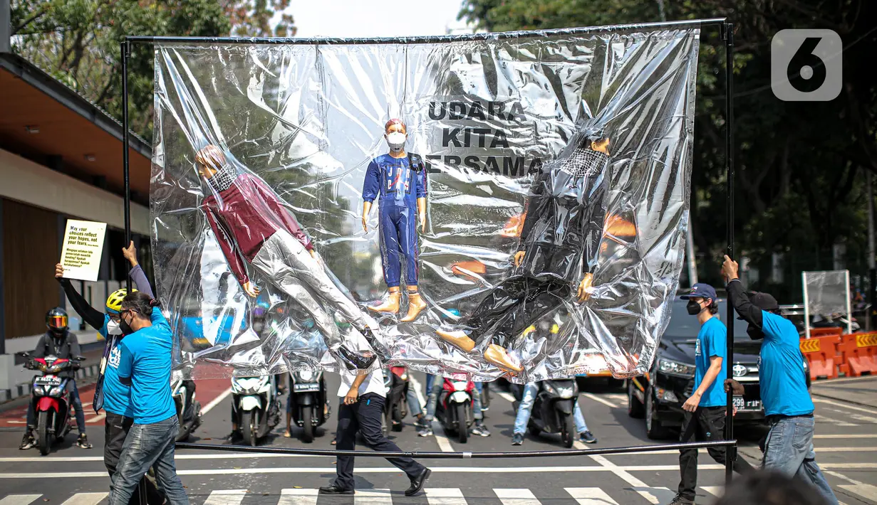Aktivis lingkungan membawa boneka menyeberangi jalan saat akan melakukan demonstrasi di depan Balai Kota DKI Jakarta, Jumat (16/9/2022). Aksi tersebut memperingati satu tahun kemenangan warga negara untuk hak udara bersih. Meski telah menang, menurut mereka belum ada satu pun putusan hakim yang dijalankan para tergugat. (Liputan6.com/Faizal Fanani)