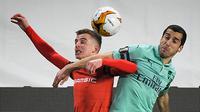 Gelandang Arsenal, Henrikh Mkhitaryan berebut bola dengan gelandang Rennes, Benjamin Bourigeaud selama pertandingan leg pertama babak 16 besar Liga Europa di Roazhon Park Prancis (7/3). Rennes menang telak 3-1. (AFP Photo/Loic Venance)