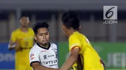 Pemain depan Madura United FC, Andik Vermansyah (tengah) mencoba melewati hadangan gelandang Bhayangkara FC, Arif Setiawan pada lanjutan Shopee Liga 1 Indonesia 2019 di Stadion Madya Gelora Bung Karno, Jakarta, Senin (5/8/2019). Laga kedua tim berakhir imbang 1-1. (Liputan6.com/Helmi Fithriansyah)