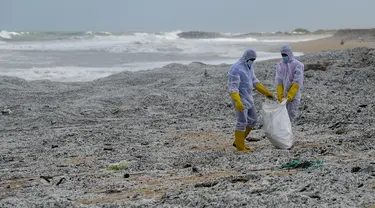 Tentara Angkatan Laut Sri Lanka menghilangkan puing-puing dari kapal kontainer MV X-Press Pearl yang terdampar di sebuah pantai di Kolombo, Jumat (28/5/2021). Kapal berbendera Singapura yang membawa 25 ton asam nitrat itu terbakar di lepas pantai Kolombo. (Ishara S. KODIKARA/AFP)