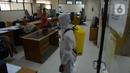 Petugas menyemprotkan cairan disinfektan di ruang kerja dan ruang pelayanan Suku Dinas Sosial Jakarta Timur, Jumat (18/2/2022). Sebanyak 6 orang yang terpapar Covid-19 sedang menjalani isolasi di rumah, sementara pelayanan ditutup selama tiga hari. (merdeka.com/Imam Buhori)