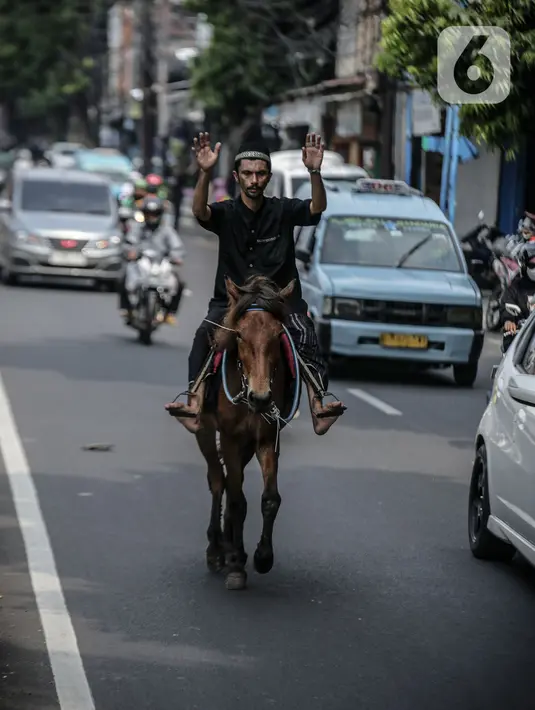Pria penunggang kuda itu terlihat masih mengenakan peci dan sarung.peci dan sarung usai melaksanakan shalat Jumat. (Liputan6.com/Faizal Fanani)
