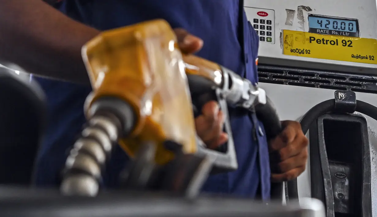 <p>Seorang karyawan melayani pengendara skuter mengisi bensin di stasiun bahan bakar Lanka IOC di Kolombo, Selasa (24/5/2022). Sri Lanka yang kekurangan uang menaikkan harga bahan bakar secara tajam ke rekor tertinggi pada 24 Mei 2022, menyebabkan penderitaan lebih lanjut bagi 22 juta orang di negara itu dalam krisis terburuk sejak kemerdekaan. (Ishara S. KODIKARA / AFP)</p>