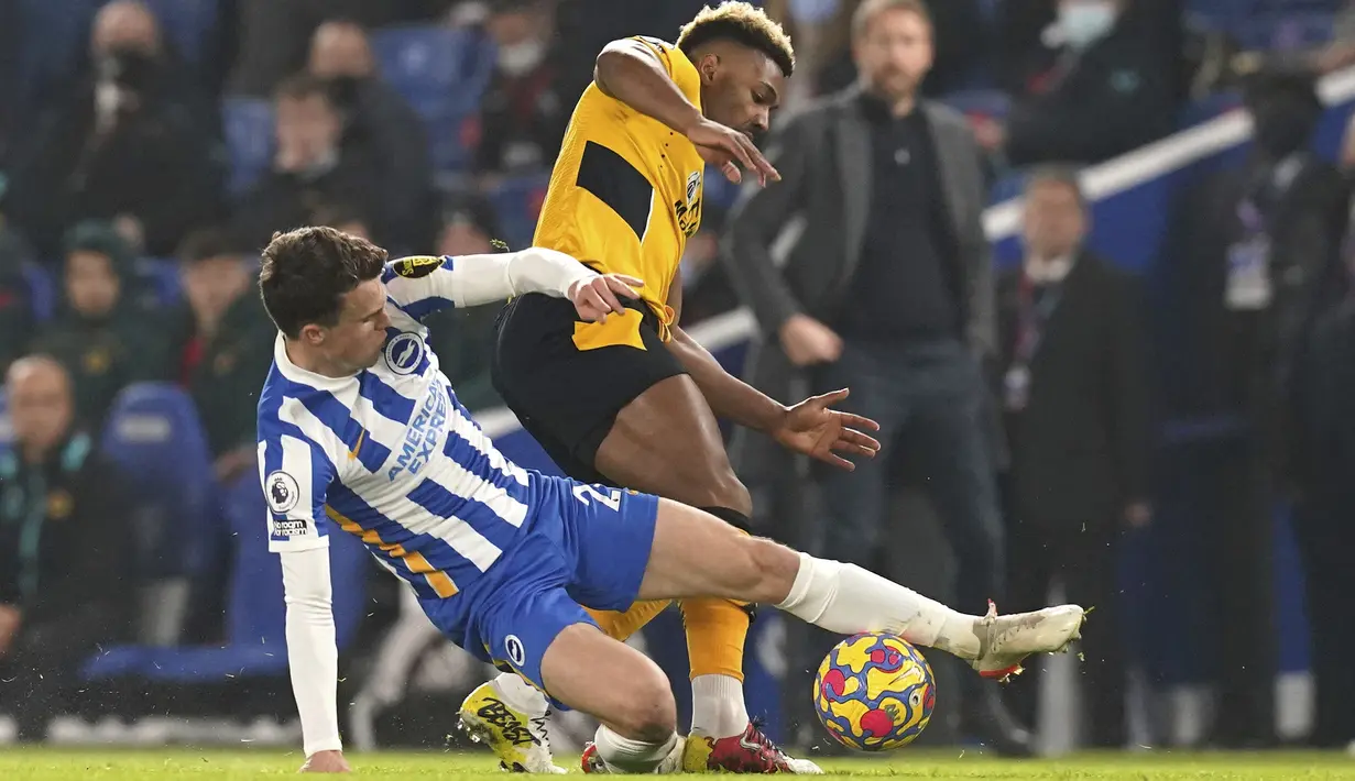 Gelandang Brighton & Hove Albion, Solly Marchl berebut bola dengan penyerang Wolverhampton Wanderers, Adama Traore pada laga pekan ke-17 Liga Inggris di Stadion Amex, Kamis (16/12/2021) dini hari WIB. Wolves mengalahkan Brighton & Hove Albion dengan skor 1-0. (Gareth Fuller/PA via AP)
