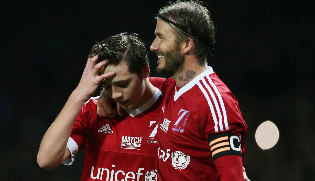 Pemain Great Britain & Ireland XI, David Beckham dan putranya Brooklyn usai tampil pada laga amal melawan World XI di Old Trafford, Inggris, Sabtu (14/11/2015) dini hari WIB. (Action Images via Reuters/Alex Morton)