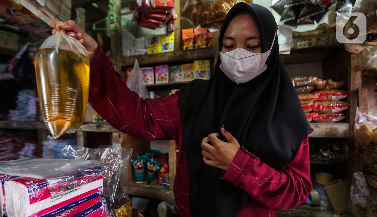Seorang pedagang menimbang minyak goreng curah di kiosnya Pasar Kebayoran Lama, Jakarta, Rabu (19/1/2022). Pemerintah resmi mengimplementasikan kebijakan minyak goreng satu harga Rp14.000 per liter untuk semua jenis kemasan mulai hari ini. (Liputan6.com/Johan Tallo)