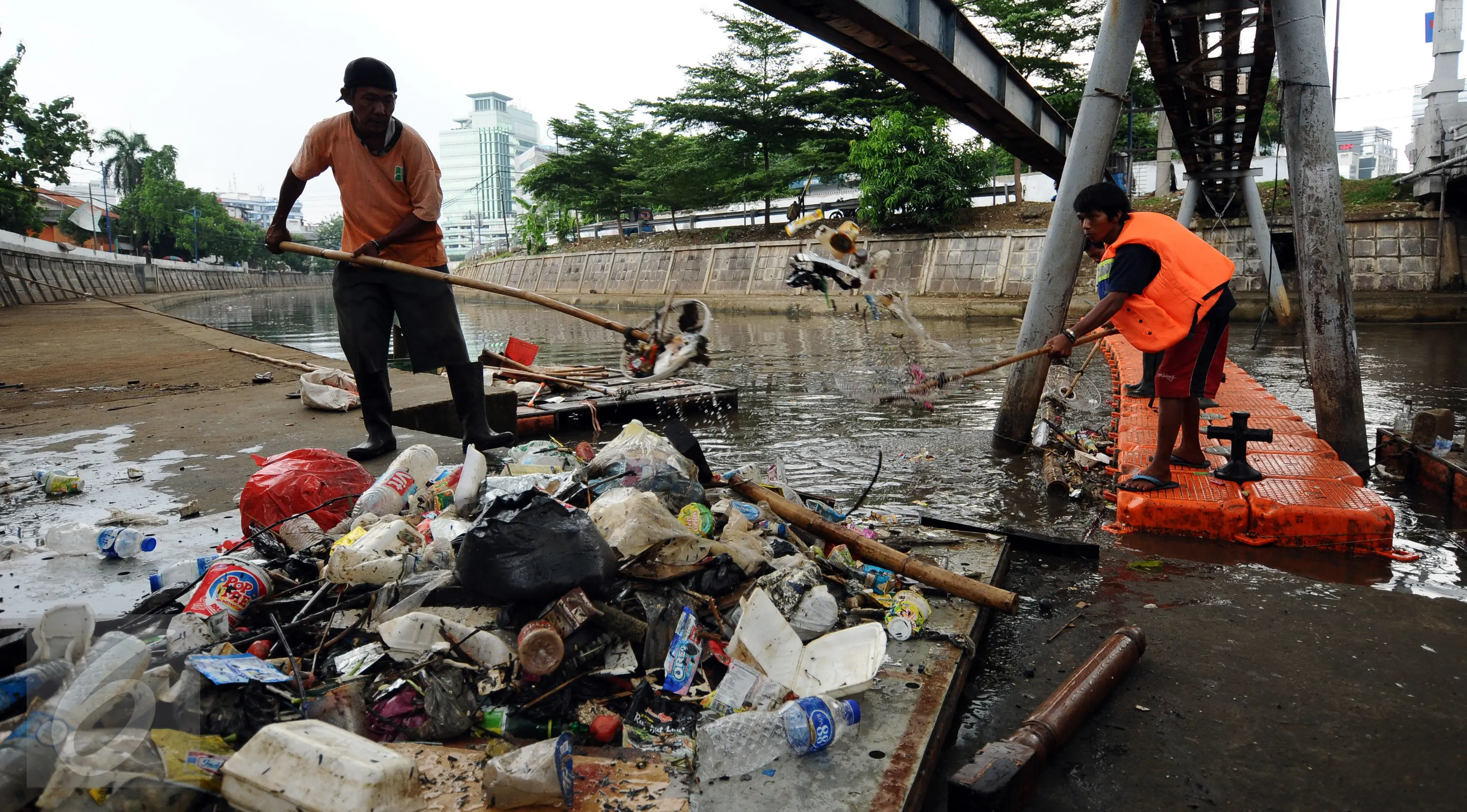 Petugas UPK Badan Air Dinas Kebersihan DKI Jakarta mengangkat sampah dari badan Kali Ciliwung Kwitang, Jakarta, Senin (10/10). Setiap harinya sekitar 90-220 ton sampah diangkat dari badan air. (Liputan6.com/Helmi Fithriansyah)