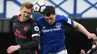 Bek Arsenal, Per Mertesacker (kiri) dan bek Everton, Michael Keane berebut bola pada matchday kesembilan Liga Primer Inggris di Goodison Park, Minggu (22/10). Bertandang ke markas Everton, Arsenal berhasil mengukir kemenangan telak 5-2. (Oli SCARFF / AFP)