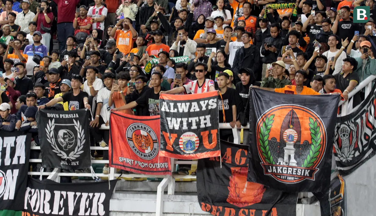 Suporter Persija Jakarta memberikan dukungan langsung kepada Macan Kemayoran saat menghadapi Persebaya Surabaya pada laga Grup B Piala Presiden 2026 di Stadion Gelora Bung Tomo, Surabaya, Minggu (26/7/2026) malam. Kehadiran pendukung Persija turut mewarnai laga debut Shin Tae-yong yang berakhir dengan kekalahan 0-1 dari Persebaya. (Bola.com/Wahyu Pratama)