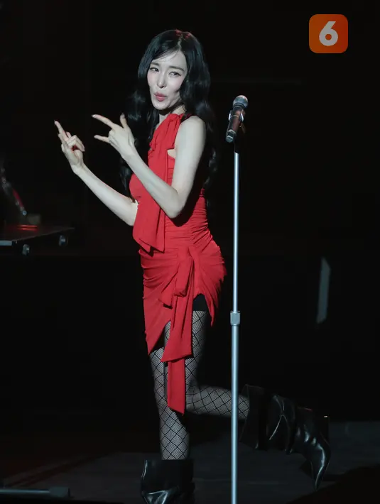 Tiffany Young tampil mengenakan gaun merah, stoking jaring-jaring, dan sepatu bot hitam saat membuka konser Edge of Calm Tour di JIEXPO Theatre Kemayoran, Jakarta, Sabtu (19/9/2026) malam. (KLY/Budy Santoso)