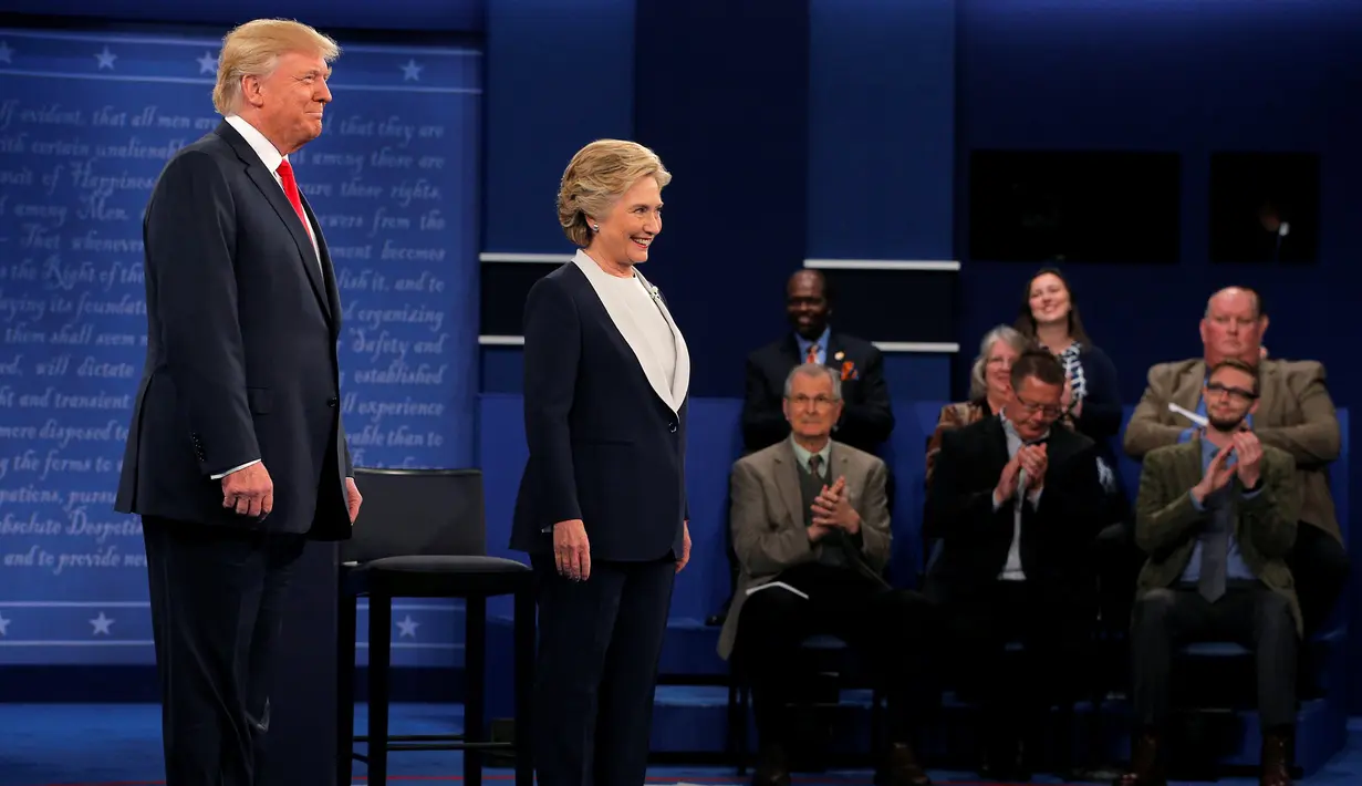 Senyum kedua capres AS Donald Trump dan Hillary Clinton sebelum debat dimulai AS di Washington University, AS, Minggu (9/10). Debat capres putaran kedua ini dimulai tanpa berjabat tangan kedua capres. (REUTERS/Brian Snyder)