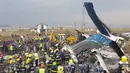 Tim penyelamat berkumpul di sekitar puing pesawat yang jatuh di dekat Bandara Internasional Kathmandu, Nepal, Senin (12/3). Sebanyak 40 orang tewas dan 23 lainnya cedera. (Prakash MATHEMA/AFP)