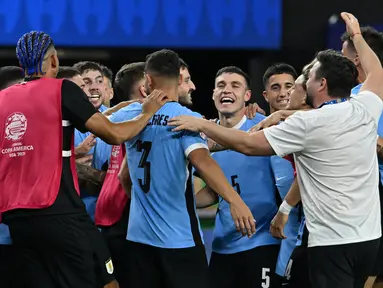 Gelandang Uruguay, Manuel Ugarte (tengah) merayakan dengan rekan setimnya setelah mencetak gol dalam adu penalti untuk memenangkan pertandingan perempat final Copa America 2024 melawan Brasil di Stadion Allegiant, Las Vegas, Nevada pada 6 Juli 2024 atau Minggu 7 Juli 2024 WIB. (Robyn BECK/AFP)