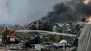 Petugas memadamkan api setelah ledakan besar di Beirut, Lebanon, Selasa, (4/8/2020). Dua ledakan besar mengguncang ibukota Lebanon, Beirut, melukai puluhan orang, menghancurkan gedung-gedung dan mengirimkan asap besar mengepul ke langit. (AFP/STR)