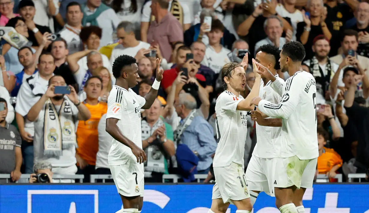 Penyerang Real Madrid, Vinicius Junior (kiri) merayakan gol kedua timnya saat pertandingan Liga Spanyol melawan Villarreal CF di stadion Santiago Bernabeu, Madrid pada Sabtu 5 Oktober 2024 atau Minggu (6/10/2024) dini hari WIB. (OSCAR DEL POZO/AFP)