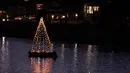 Perahu melewati lampu pohon Natal yang mengapung di Long Beach, California, Minggu (19/12/2021). Sambut Natal, pantai di California menghiasi pantainya dengan hiasan lampu pohon Natal. (AP Photo/Ashley Landis)