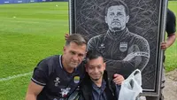 Seorang bobotoh asal Aceh, Khairil Fikri, memberikan lukisan kepada pemain dan pelatih Persib Bandung di Lapangan Pendamping Stadion Gelora Bandung Lautan Api, Bandung, Jumat (30/10/2026). (Bola.com/M. Faqih)