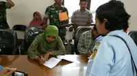 Salah satu anggota keluarga menerima santunan untuk penerjun payung yang meninggal dunia saat latihan persiapan HUT ke-70 TNI AU. (Liputan6.com/Nanda Perdana Putra)