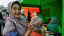  Warga menunjukan daging sapi yang dijual dalam operasi pasar murah PD Pasar Jaya, Jakarta, Kamis (9/6/2016). Pasar murah menjual daging sapi paha belakang di harga Rp89 ribu/kg dan untuk daging sapi paha depan Rp85 ribu/kg. (Liputan6.com/Yoppy Renato)