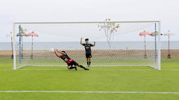 Sejumlah pesepak bola cilik bermain bola di Training Ground Bali United, Gianyar, Senin (28.03/2022). Mereka tampak senang menjajal lapangan latihan Bali United yang berada di pinggir pantai. (Bola.com/ M Iqbal Ichsan)