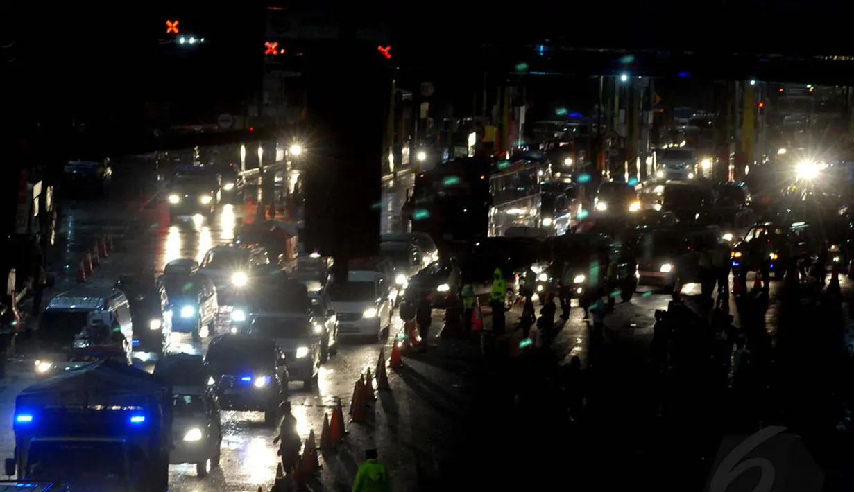 Hingga larut malam, sejumlah aparat kepolisian terus berjaga mengantisipasi meningkatnya kepadatan kendaraan di pintu keluar tol Cikampek menuju jalur Pantai Utara pulau Jawa, (27/7/2014). (Liputan6.com/Miftahul Hayat)