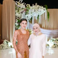 Untuk melengkapi busananya, Aurel memilih hijab segi empat bernuansa nude yang senada dengan palet ivory pada gaun.  [@aurelie.hermansyah].