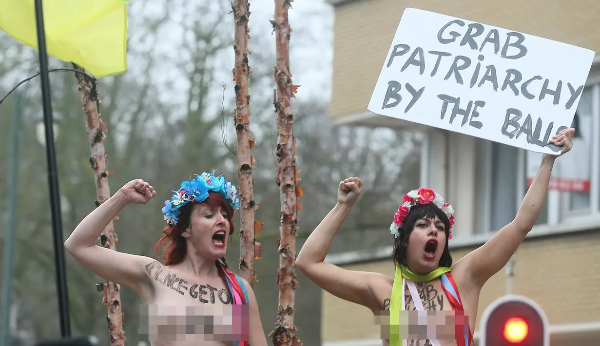 Dua orang wanita melakukan aksi telanjang dada memprotes kebijakan Presiden AS Donald Trump di sela-sela kunjungan Wakil Presiden AS, Mike Pence ke Belgia di Brussel, Senin (20/2). (AFP Photo/ JOHN THYS)