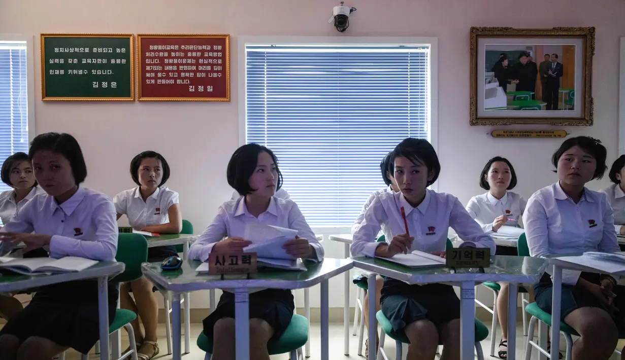 Sejumlah siswi berada di dalam kelas di sebuah perguruan tinggi pelatihan guru di Pyongyang, Korea Utara (7/9). Jelang HUT Kemerdekan Korea Utara ke-70, pemerintah pusat mengizinkan wartawan asing meliput beberapa tempat di Korut. (AFP Photo/Ed Jones)