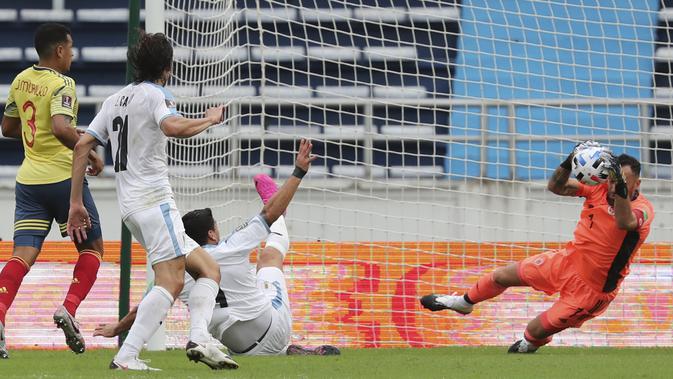 Penjaga gawang Kolombia David Ospina menghentikan tembakan pemain Uruguay Luis Suarez selama pertandingan sepak bola kualifikasi untuk Piala Dunia FIFA Qatar 2022 di stadion Metropolitano di Barranquilla, Kolombia, Jumat, 13 November 2020. (Foto AP / Fern