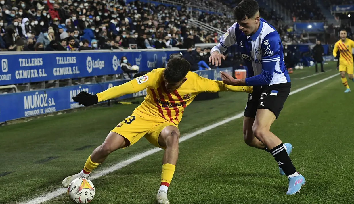 Penyerang Barcelona Abdessamad Ezzalzouli berebut bola dengan bek Deportivo Alaves Javi Lopez dalam duel pekan ke-22 La Liga 2021/22, di Estadio Mendizorroza, Senin (24/1/2022) dini hari WIB. Gol telat Frenkie De Jong memenangkan Barcelona 1-0. (AP Photo/Alvaro Barrientos)