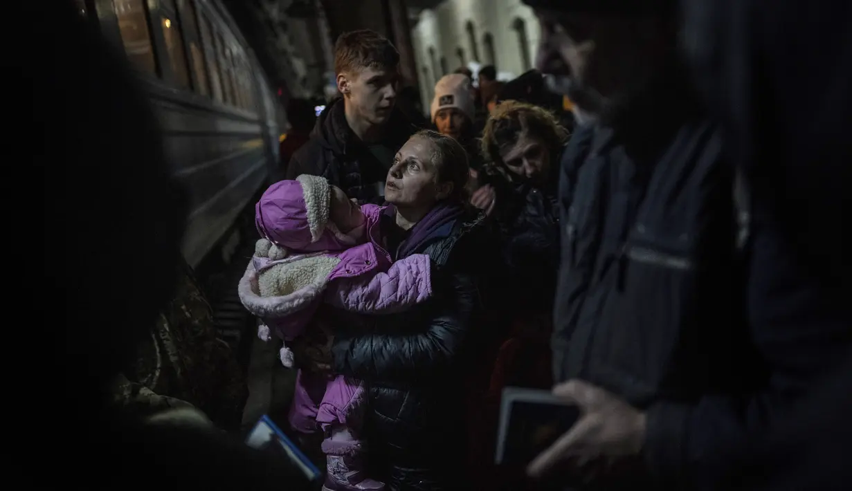 Pengungsi Ukraina menunggu untuk naik kereta api tujuan Polandia di Lviv, Ukraina barat, 13 Maret 2022. Tepat pada hari ini, Kamis, 24 Maret 2022, invasi Rusia ke Ukraina sudah terhitung genap satu bulan penuh. (AP Photo/Bernat Armangue)