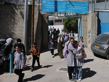 Siswi-siswi Palestina meninggalkan sekolah United Nations Relief and Works Agency for Palestine Refugees in the Near East atau Lembaga Bantuan dan Pekerjaan Perserikatan Bangsa Bangsa (PBB) untuk Pengungsi Palestina (UNRWA) di kamp pengungsi Shoafat, Yerusalem timur pada 8 Mei 2025. (AHMAD GHARABLI/AFP)
