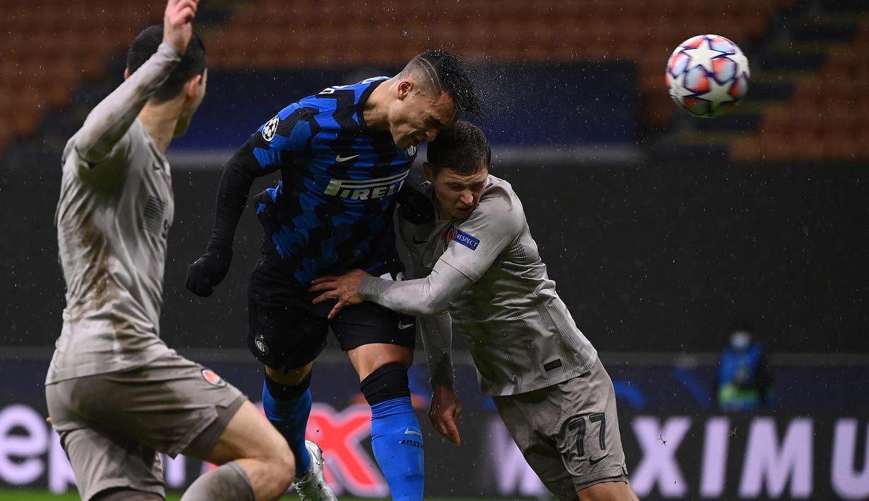 Striker Inter Milan, lautaro Martinez (tengah), melepaskan sundulan dibawah tekanan bek Shakhtar Donetsk, Valeriy Bondar, dalam laga lanjutan Liga Champions 2020/21 Grup B di San Siro Stadium, Rabu (9/12/2020). Inter Milan bermain imbang 0-0 dengan Shakhtar Donetsk. (AFP/Marco Bertorello)