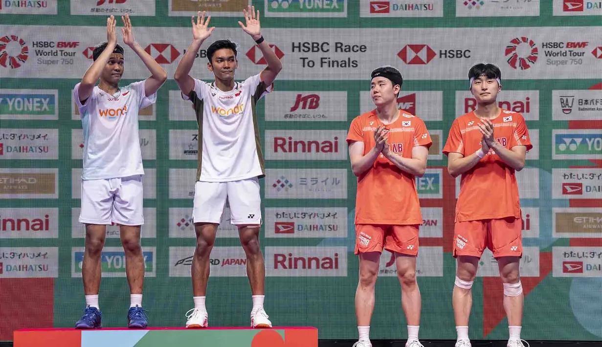 Ganda putra Indonesia Fajar Alfian dan Muhammad Shohibul Fikri merayakan kemenangan atas ganda putra Korea Selatan Kim Won-ho dan Seo Seung-jae usai pertandingan final ganda putra turnamen bulu tangkis Japan Open di Tokyo Gymnasium, Tokyo, pada 19 Juli 2026. (AFP/  Yuichi Yamazaki)