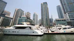 Kapal pesiar mewah bersandar di Dubai Marina Beach di emirat Teluk, pada 10 Juni 2021. Di tengah aturan pandemi di mana warga harus menjaga jarak dan menghindari keramaian, orang-orang kaya di Dubai memiliki cara mereka bisa pergi berekreasi, yaitu jalan-jalan dengan kapal pesiar. (Karim SAHIB/AFP)