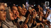 Penonton bernanyi saat menyaksikan konser yang bertajuk 'Tunggu Aku di Jakarta' di kawasan JIExpo Kemayoran, Jakarta, Sabtu, (28/1/2023). Dalam konser yang bertajuk 'Tunggu Aku di Jakarta', Sheila on 7 membawakan lagu-lagu andalannya seperti Pejantan Tangguh, Pria Kesepian, Sephia dan lain-lain. (Liputan6.com/Herman Zakharia)