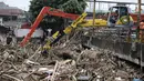 Alat berat mengangkat ratusan ton sampah yang menumpuk di Jembatan Jalan KH Abdullah Syafei, Jakarta, Selasa (6/2). Hingga kini, Dinas Lingkungan Hidup DKI Jakarta telah mengangkut 700 ton sampah. (Liputan6.com/Arya Manggala)