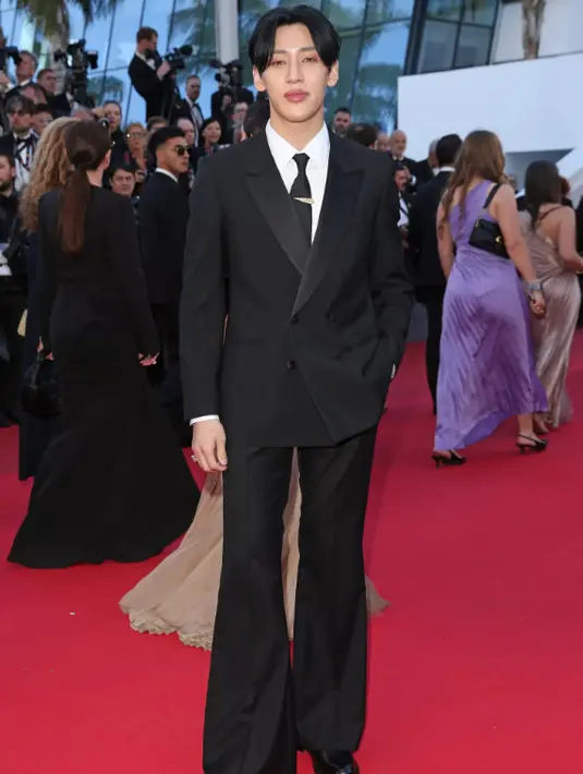 BamBam mengenakan jaket tuksedo double-breasted hitam, dan celana dengan cutting lebar. Kemeja katun poplin putih, dasi sutra hitam, dan sepatu bot Chelsea LV City kulit hitam. BamBam juga mengenakan bros Fortune bertatahkan satu berlian LV Monogram Star cut 1,05 karat dari koleksi Louis Vuitton High Jewelry Louis Vuitton Mythica.