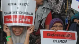 Aktivis menunjukkan poster berisi dukungan saat menggelar aksi di halaman gedung KPK, Jakarta, Jumat (13/3/2015). Mereka menolak kriminalisasi KPK yang selama ini konsisten melakukan upaya pemberantasan korupsi. (Liputan6.com/Herman Zakharia)