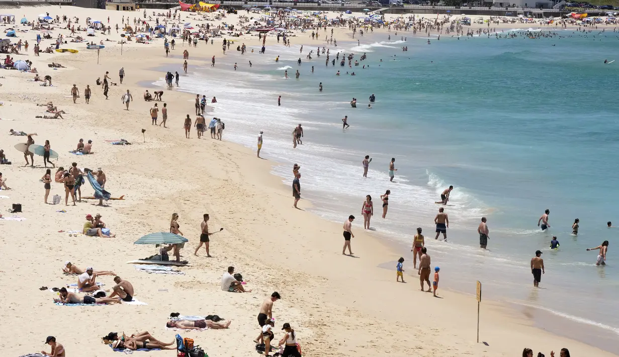 <p>Orang-orang berkumpul di Pantai Bondi saat merayakan Natal di Sydney, Sabtu (25/12/2021). (AP Photo/Rick Rycroft)</p>