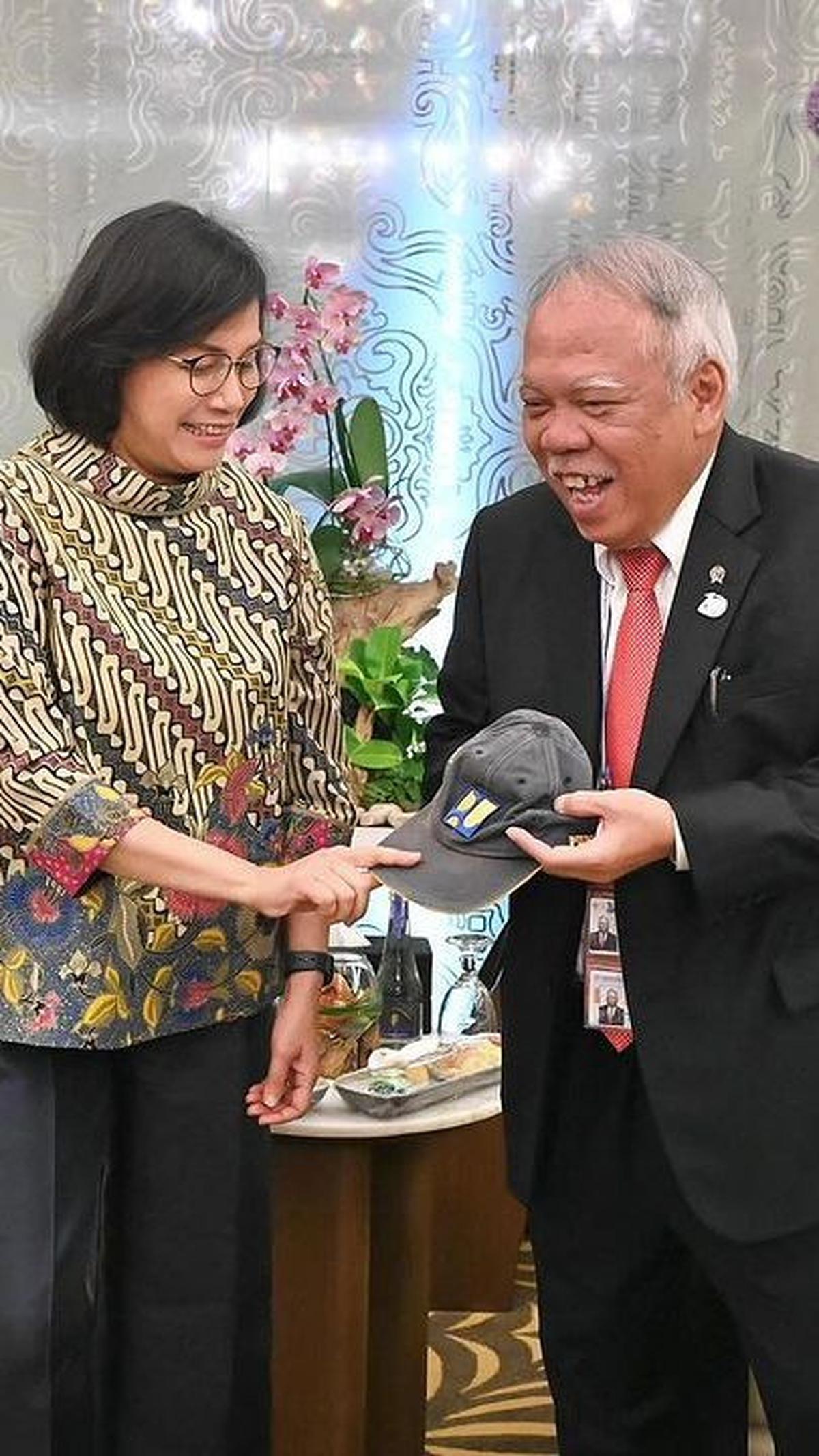 Pada potret yang dibagikan di akun instagram Sri Mulyani tampak Basuki meminjamkan topinya itu kepada sang menkeu.&nbsp;<br>