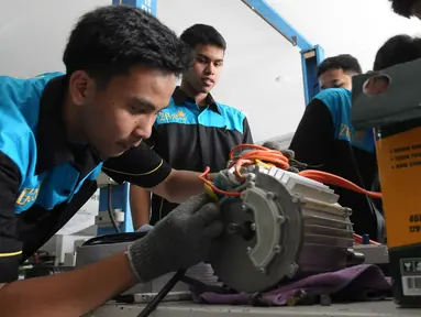 Pelajar SMK Negeri 26 Jakarta melakukan pengecekan instalasi part konversi mobil listrik di Bengkel Otomotif SMKN 26, Jakarta, Rabu (13/5/2023). (merdeka.com/Imam Buhori)