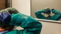 Seorang perawat mengenakan peralatan kerjanya untuk memulai shift di rumah sakit Cremona, tenggara Milan, Lombardy, 12 Maret 2020. Para pekerja kesehatan Italia kelelahan setelah selama bermingu-minggu mereka yang berada di garda terdepan memerangi pandemi virus corona. (Paolo MIRANDA/AFP)
