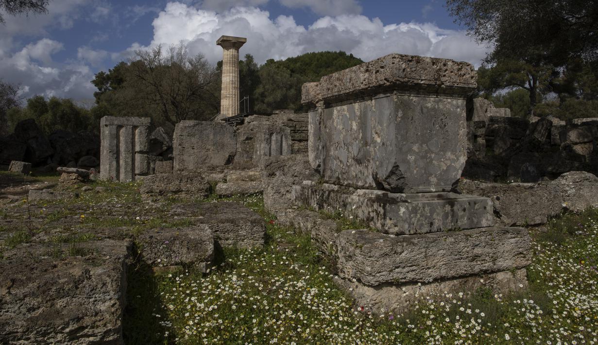 Bunga di depan Kuil Zeus dibangun pada pertengahan abad ke-5 SM di Olympia, tempat penyelenggaraan Olimpiade Yunani Kuno, Senin (23/3/2021). Pemerintah Yunani membuka kembali situs-situs kuno secara nasional untuk memulai lagi musim pariwisata pada pertengahan Mei. (AP Photo/Petros Giannakouris)