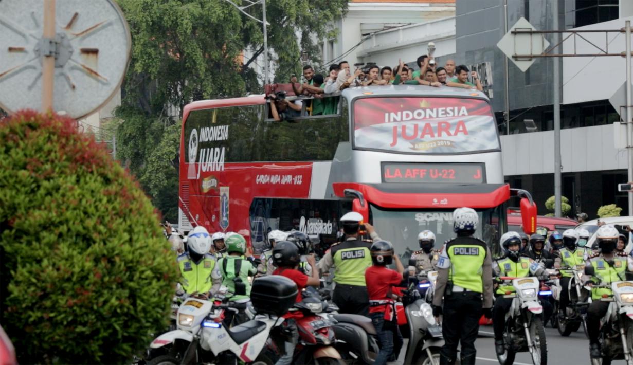 Pemain dan ofisial Timnas Indonesia U-22 menaiki bus tingkat saat konvoi menuju Istana Negara Jakarta, Kamis (28/2). Pawai tersebut untuk merayakan keberhasilan skuat Garuda Muda menjuarai Piala AFF U-22 di Kamboja. (Bola.com/Muhammad Husni)