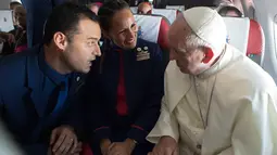 Paus Fransiskus (kanan) memberi nasihat kepada pasangan pramugari Paula Podest dan Carlos Ciuffardi usai dinikahkan di atas pesawat selama penerbangan di antara Santiago dan kota utara Iquique (18/1). (HO/Osservatore Romano/AFP)