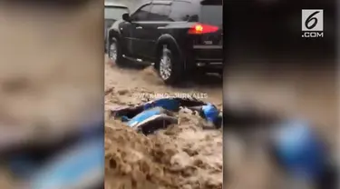 Video amatir menampilkan sebuah sepeda motor terseret arus banjir di kawasan Cipanas, Puncak, Jawa Barat.