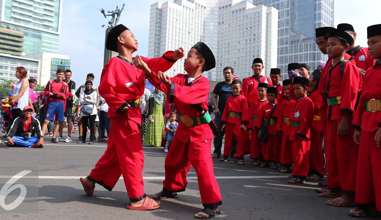 Dua pendekar cilik memamerkan keahlian beladiri di di Jakarta, Minggu (7/8). Sekitar 1000 pendekar memadati Bundaran HI untuk merayakan Lebaran Pendekar Betawi 2016. (Liputan6.com/Angga Yuniar)
