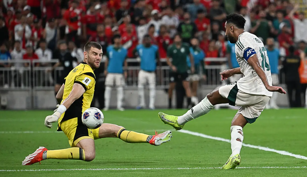 Kiper Timnas Indonesia, Maarten Paes, berusaha menghalau bola tendangan Pemain Arab Saudi, Saleem Al Dawsari, pada laga Grup B putaran keempat Kualifikasi Piala Dunia 2026 Zona Asia di King Abdullah Sports City Stadium, Jeddah, pada Kamis (9/10/2025) dini hari WIB. (AP Photo)