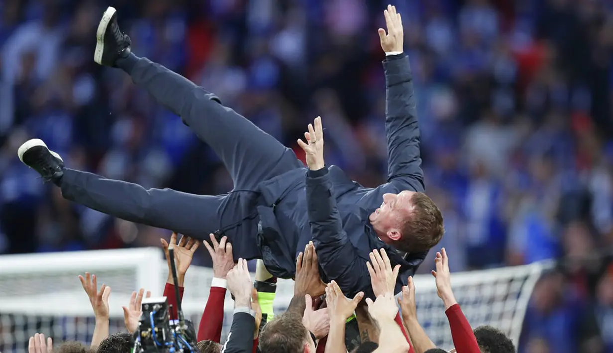 Manajer Leicester City Brendan Rodgers dilemparkan ke udara oleh para pemainnya saat mereka merayakan kemenangan atas Chelsea pada pertandingan final Piala FA di Stadion Wembley, London, Inggris, Sabtu (15/5/2021). Leicester City mengalahkan Chelsea 1-0. (AP Photo/Kirsty Wigglesworth, Pool)